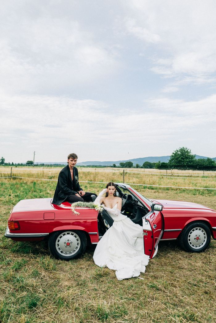 Brautpaar am roten Oldtimer-Cabrio